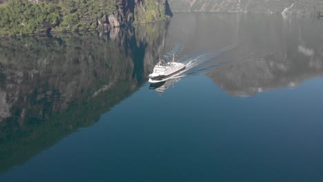 the ferry sails slowly through a quiet norwegian fjord