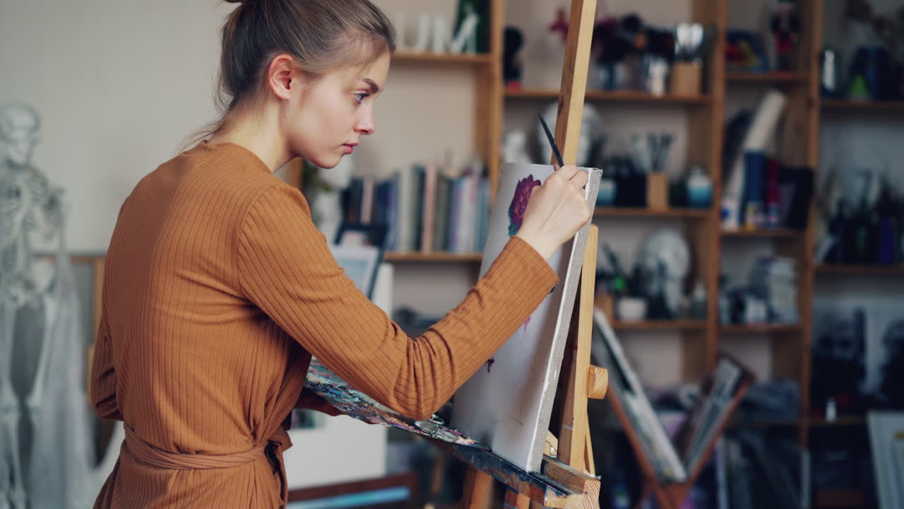Kvindelig kunstner, der maler i atelier