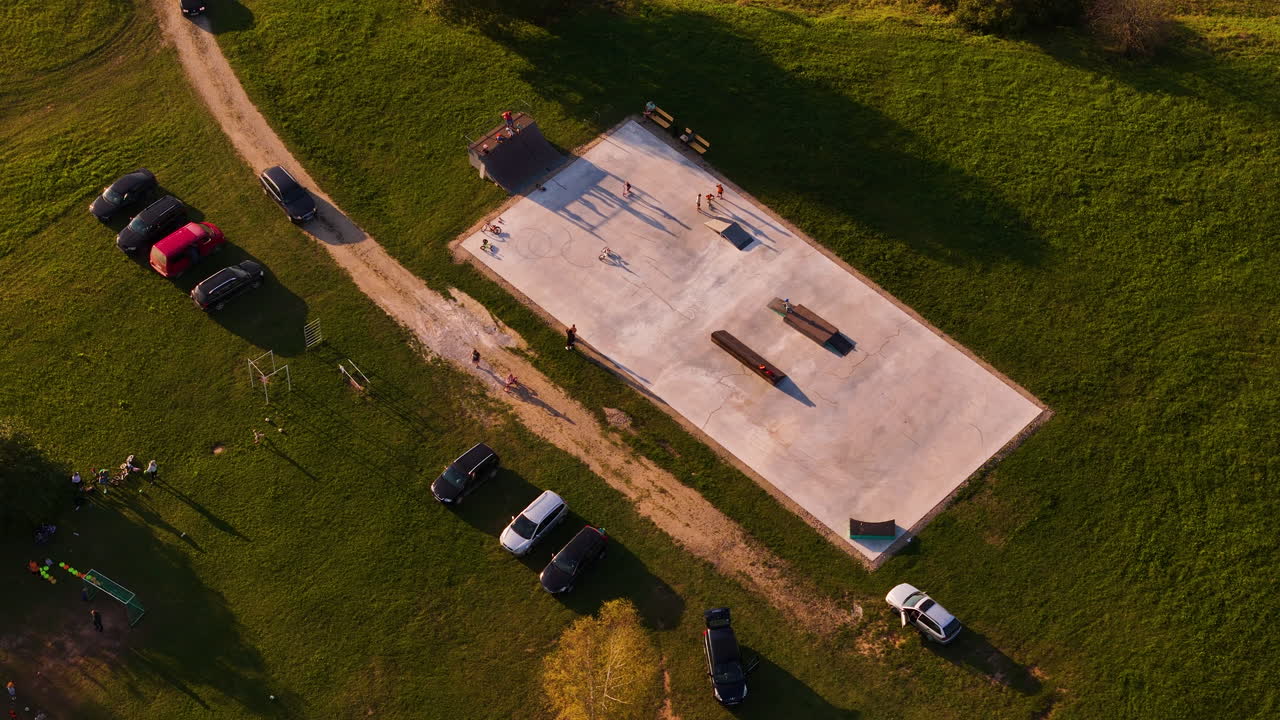 Children playing on concrete area in town of Augsligatne at sunset, Latvia. Aerial