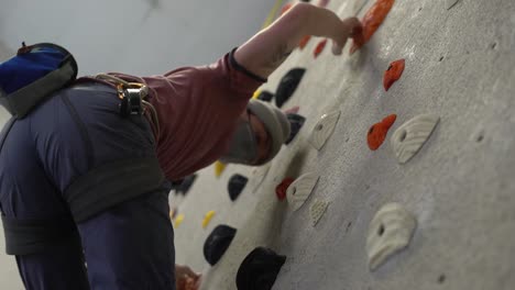 rock climber climbing an indoor rock wall using athletic chalk for grip-9