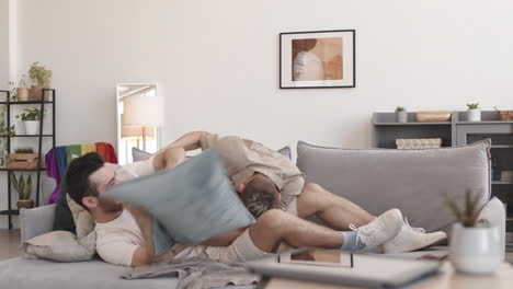 two young men having fun on sofa at home