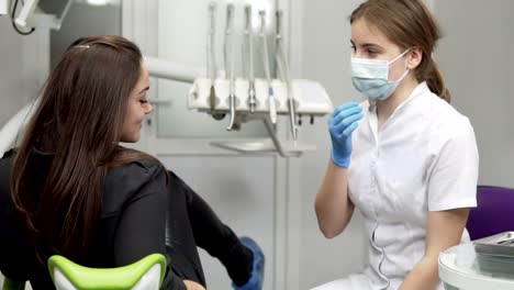 paciente joven en la consulta del dentista en la clínica de ortodoncia. escuchando los consejos del médico después de la inspección