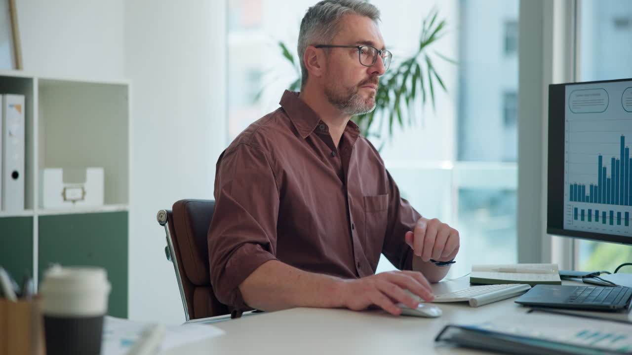 Fokuseret Forretningsmand Arbejder på Computer i Moderne Kontor