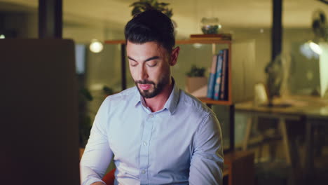 Business-man-stretching-at-his-desk-while-working