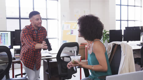 Diverse-male-and-female-colleagues-having-break,-looking-at-smartphone-and-talking,-slow-motion