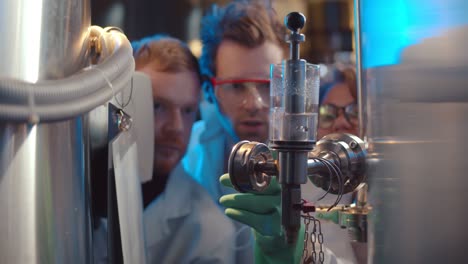 Scientists controlling chemical process at manufacturing in chemistry laboratory