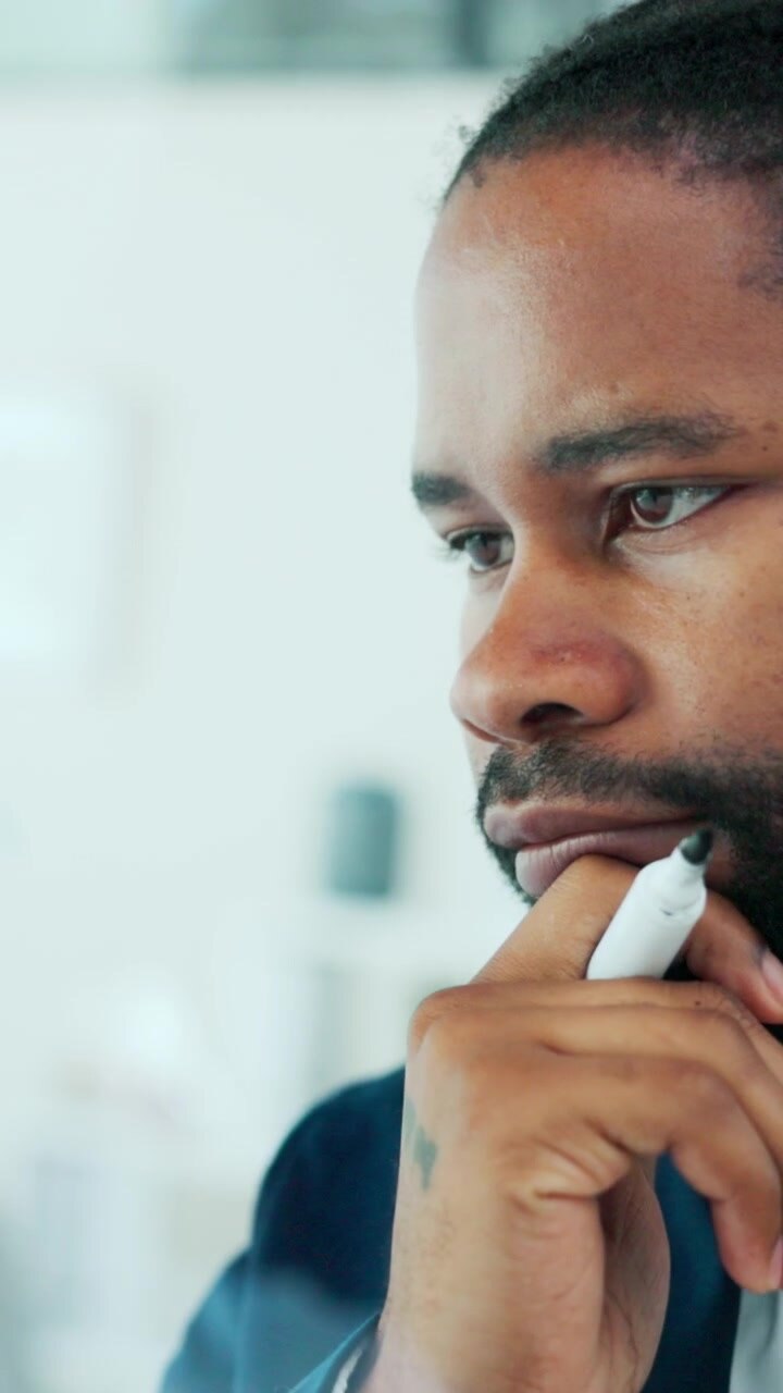 Thoughtful Businessman Holding Marker in Modern Office