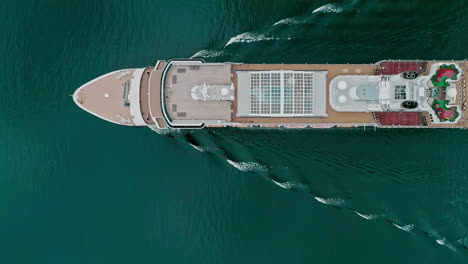 cruise liner sailing through deep water, aerial top down view