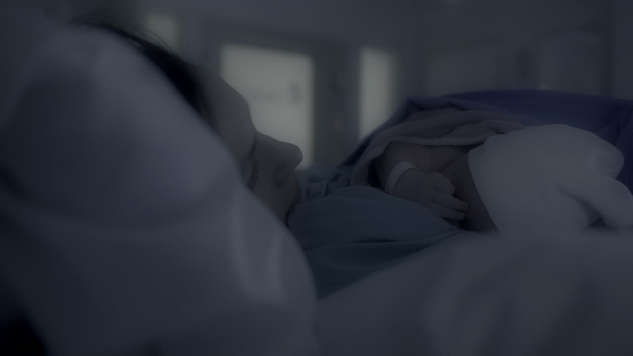 Mother and Newborn Baby Sleeping Peacefully in Hospital Bed