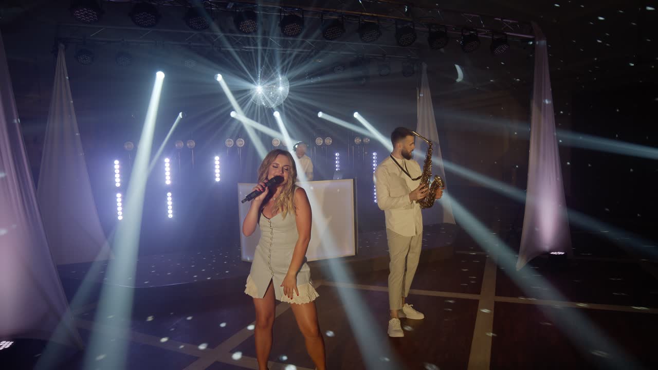 보컬리스트, 색소폰 연주자, dj 가 노래를 연주하고, 뮤지션 콘서트 무대에서 공연하는 음악 밴드 그룹