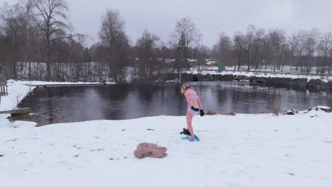 Aerial-reveal-shot-leaving-the-ice-bather-small-in-the-snowy-swedish-landscape