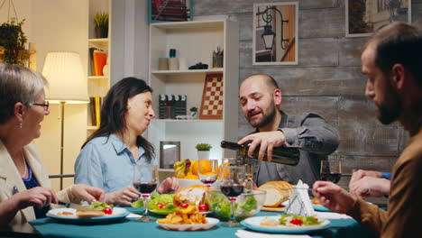 husband pouring red wine to her beautiful wife