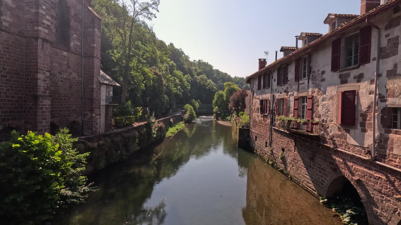 Old Europe townscape: Small river canal runs between brick buildings