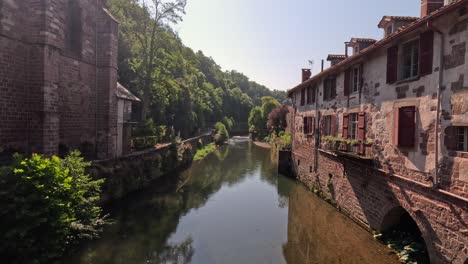 old europe townscape: small river canal runs between brick buildings