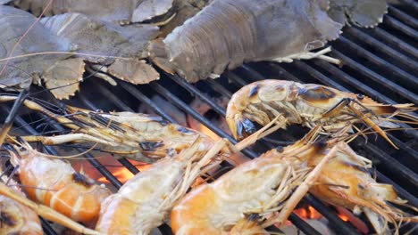 grill cooking slipper lobster and river prawns on hot charcoal in thailand seafood restaurant