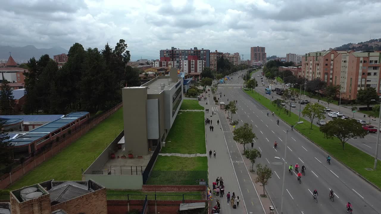 un avión no tripulado volando sobre la avenida con personas caminando