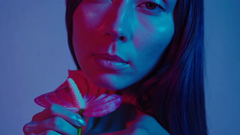 vibrant portrait of a woman with an anthurium flower in neon lights