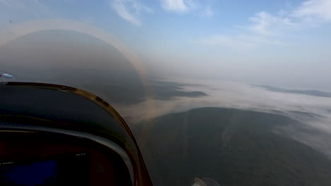 airborne view from airplane cockpit, fog covered landscape below, pilots perspective flying cross country, freedom above the clouds