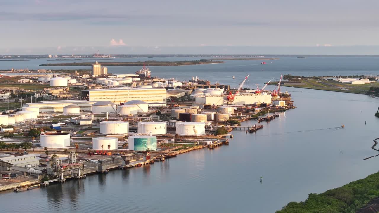 석유 저장 크와 크레인과 함께 수로 근처에 있는 산업 항구, 아마도 파 항구 지역