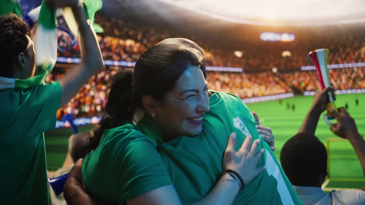 Aficionados al fútbol eufóricos abrazándose en las gradas del estadio después de un gol