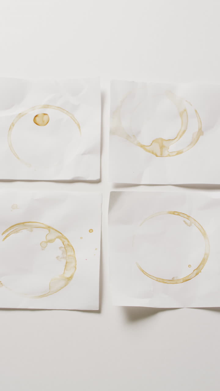 Vertical video of close up of four white memo notes with circle glass marks with copy space