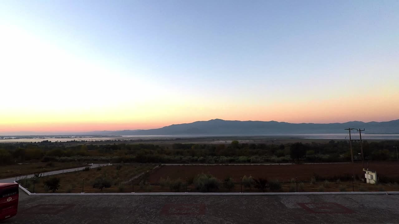 Timelapse during sunrise of a valley with a mountain in the distance