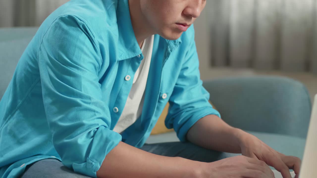 집에서 노트북으로 타이핑하는 동안 걱정하는 아시아 남자의 클로즈업