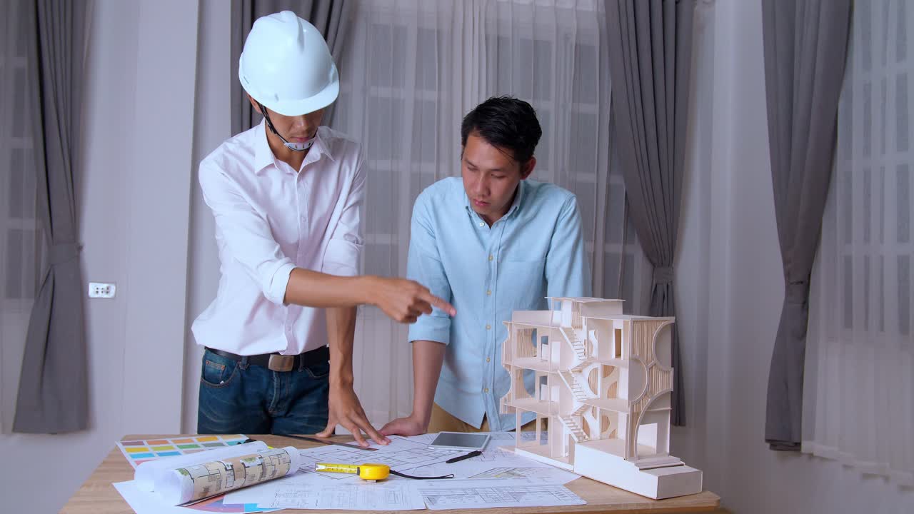 Two Young Asian Architects Working On New Architectural House Model