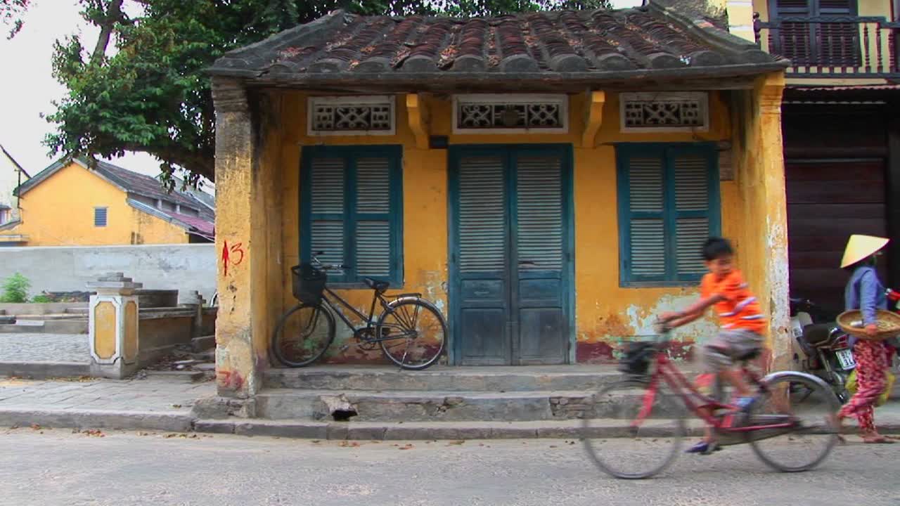 사람과 차량은 시골 베트남의 작은 건물로 움직입니다.