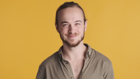 caucasian young man waving hello to the camera.