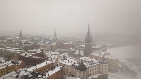 Beautiful-wide-aerial-footage-of-city-skyline-during-winter-in-a-smooth-sideway-and-slight-downward-panning-motion