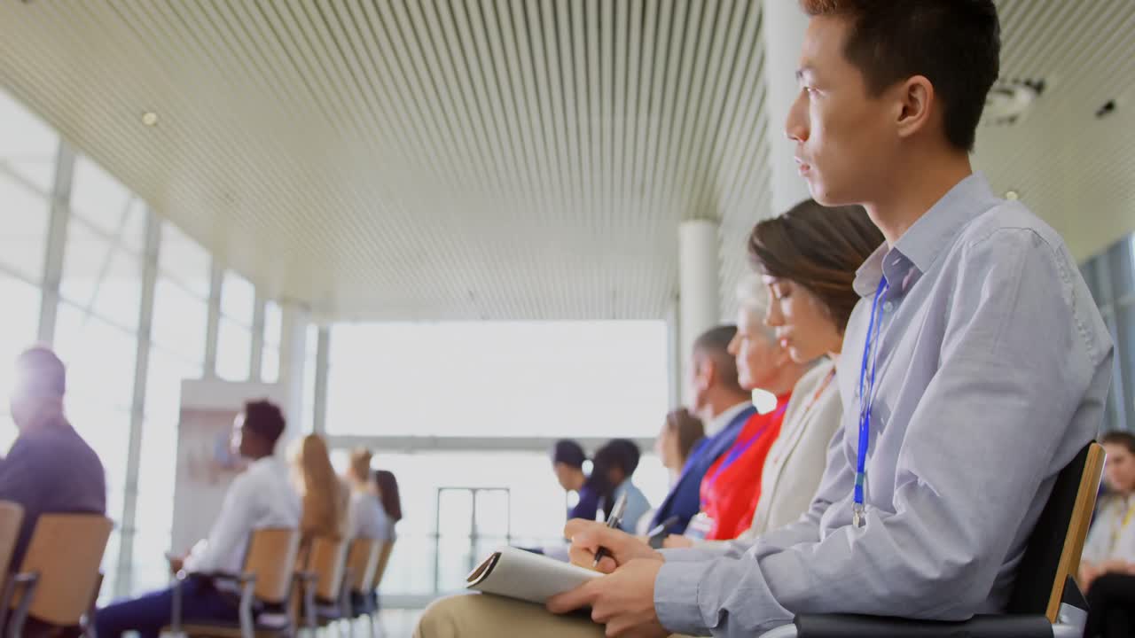 Professionisti che prendono appunti su un blocco note al seminario aziendale 4k