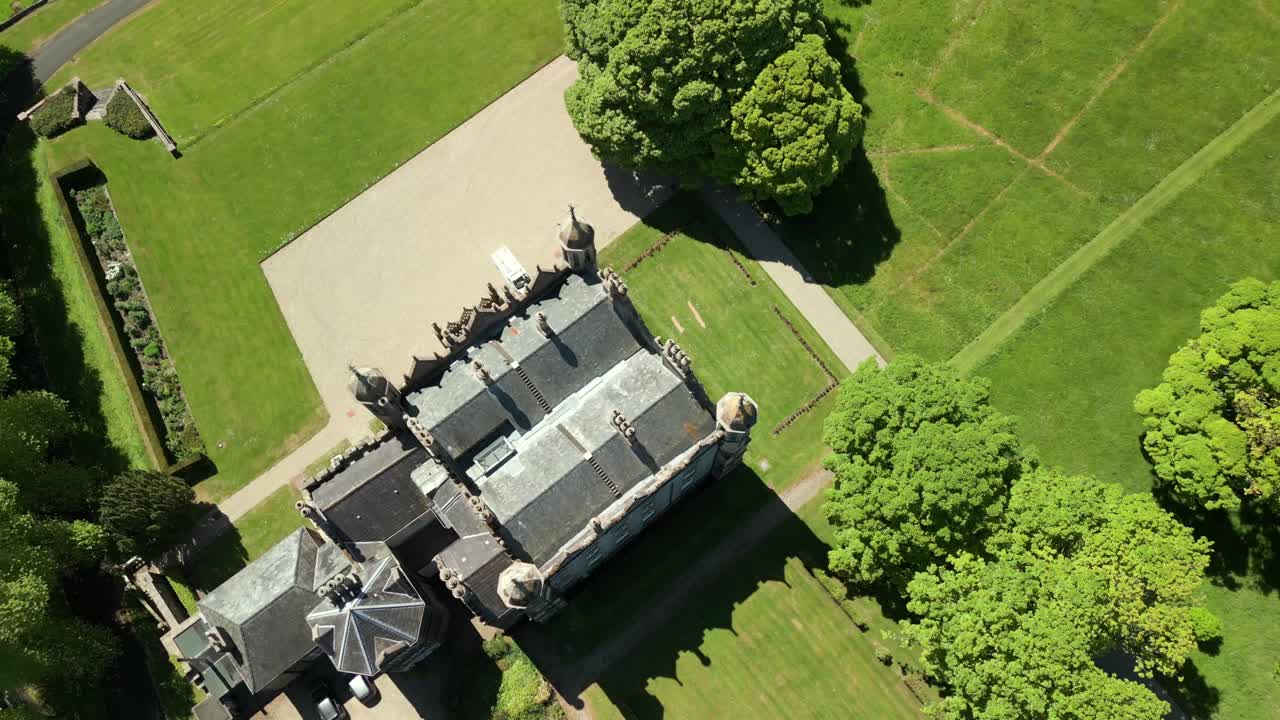 Rising overhead aerial video of Glenarm Castle and Grounds, in Glenarm, County Antrim, Northern Ireland, UK on a bright and sunny day. Filmed in 4K, 60FPS and with Rec709 color.