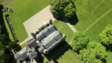 rising overhead aerial video of glenarm castle and grounds, in glenarm, county antrim, northern ireland, uk on a bright and sunny day. filmed in 4k, 60fps and with rec709 color.