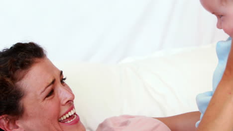 Baby-boy-in-blue-babygro-playing-with-his-mother