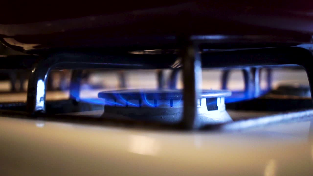 푸른 불꽃을 밝히는 주방 쿡탑의 가스 버너, 클로즈업