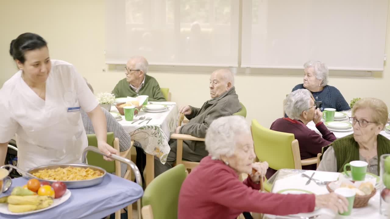 Cook serving food in the dinning room of a geriatric