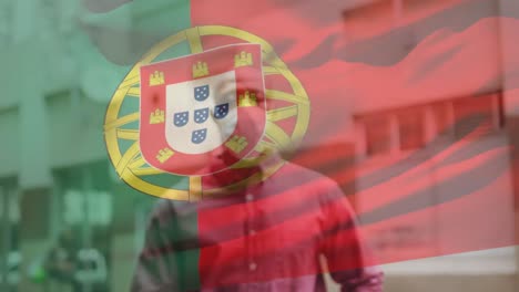 animation of flag of portugal waving over african american man wearing face mask in city street