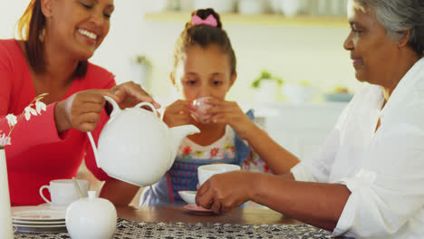 Happy-multi-generation-family-having-tea-in-dining-table-4k