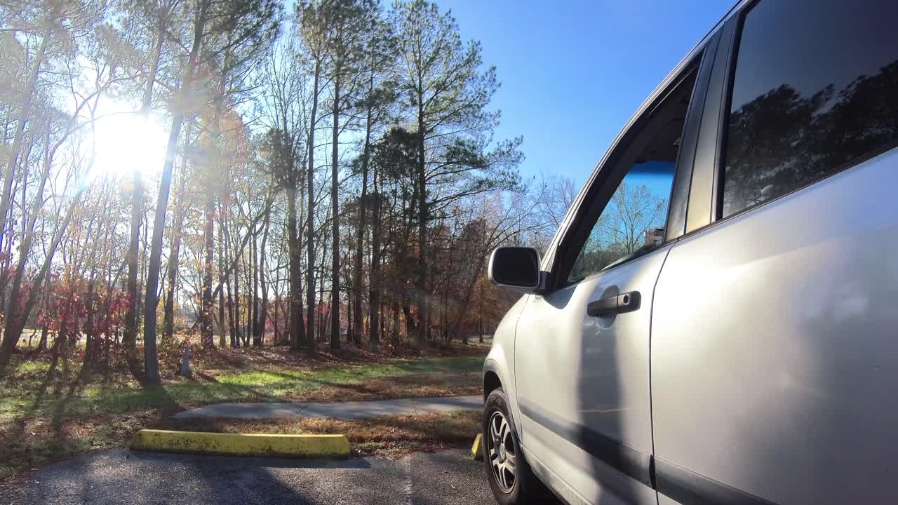 나무와 은 파란 하늘을 통해 빛나는 아름다운 은 날에 차의 창문에서 mavic 미니 드론을 발사합니다.