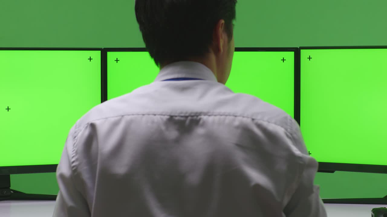 초록색 화면 을 가진 여러 컴퓨터 모니터 앞 에서 축하 하는 사업가