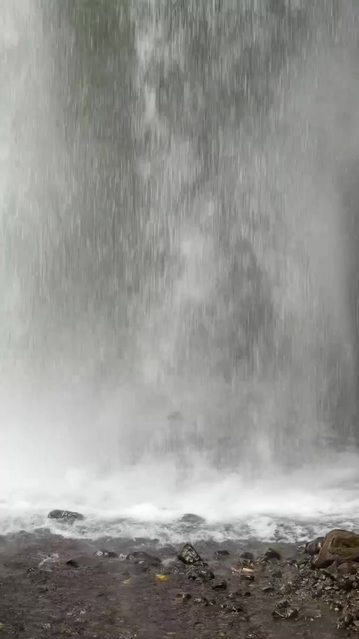 Powerful Waterfall Cascading Over Rocky Cliffside in Lush Forest