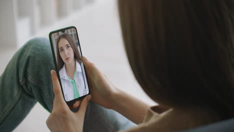 La-Mujer-Verifica-Los-Posibles-Síntomas-Con-Un-Médico-Profesional-Mediante-Video-Chat-En-Línea.-Niña-Enferma-En-Casa-Usando-Un-Teléfono-Inteligente-Para-Hablar-Con-Su-Médico-A-Través-De-Una-Aplicación-Médica-De-Videoconferencia.