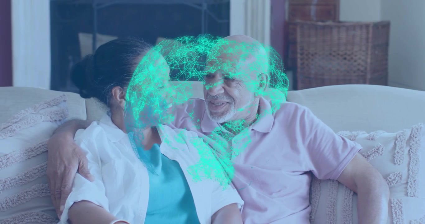 senior couple glancing upward and sparking health hologram of green heart floating between faces