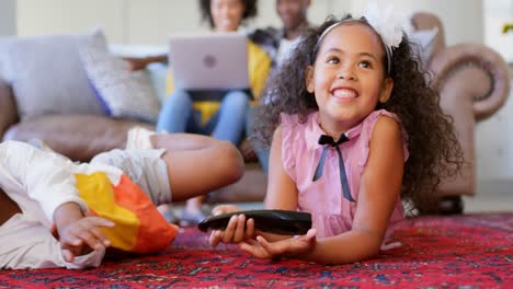 Vista-Frontal-De-Lindos-Hermanos-Negros-Viendo-Televisión-En-La-Sala-De-Estar-De-Una-Cómoda-Casa-4k