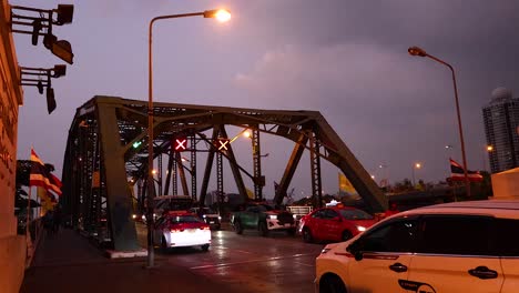 vehicles and motorcycles crossing the bridge at dusk