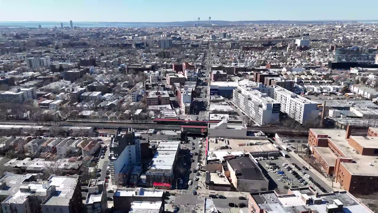 Horizontal drone arc shot over Avenue M in Brooklyn, capturing the city's vibrant streets, residential buildings, and dynamic urban skyline with a smooth, sweeping aerial motion.