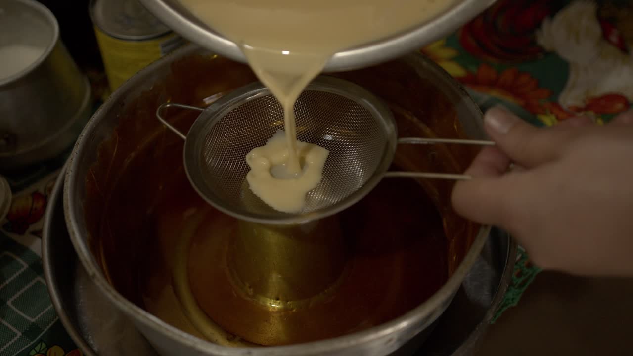 vista de cerca de un flan casero redondo servido en un plato de horneado de metal junto a un plato blanco en una mesa con un mantel acogedor