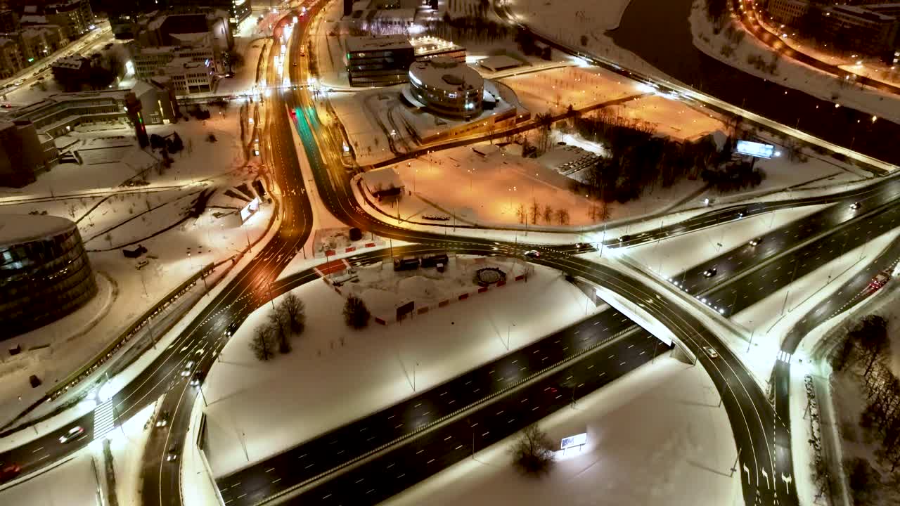 Roundabout and skyscrapers in Vilnius city center at night. Drone footage taken in winter.