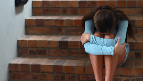 triste colegiala sentada sola en la escalera